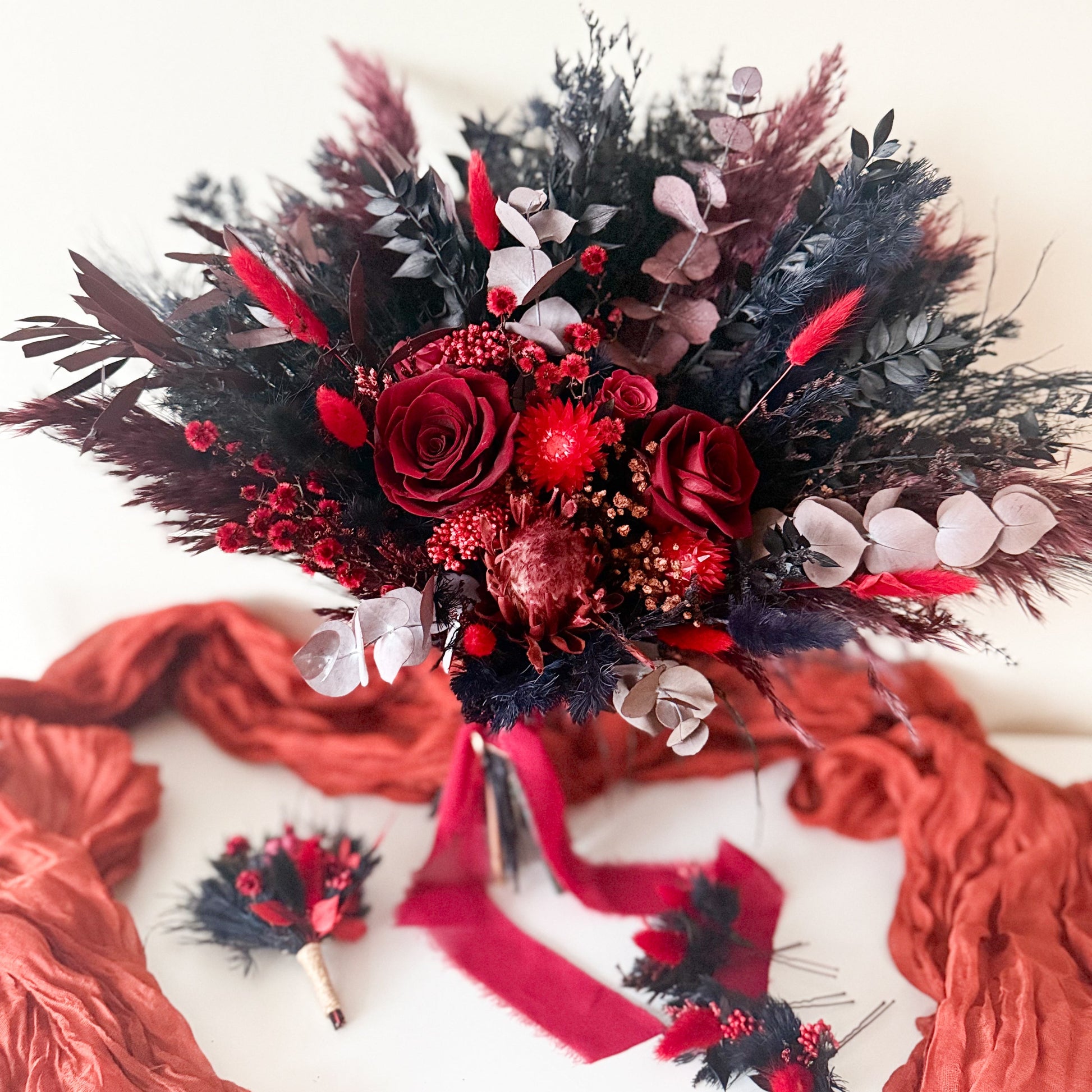 Bouquet of red and black flowers with ribbons on a white background