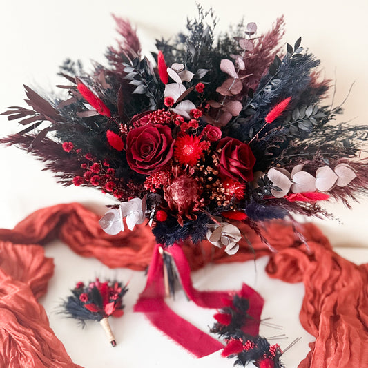 Bouquet of red and black flowers with ribbons on a white background