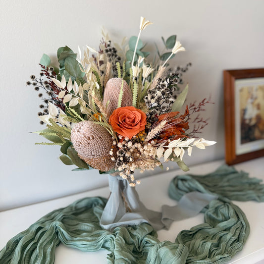 Dried flower bridal bouquet with banksia, preserved rose, eucalyptus and native greenery, rustic boho wedding style.