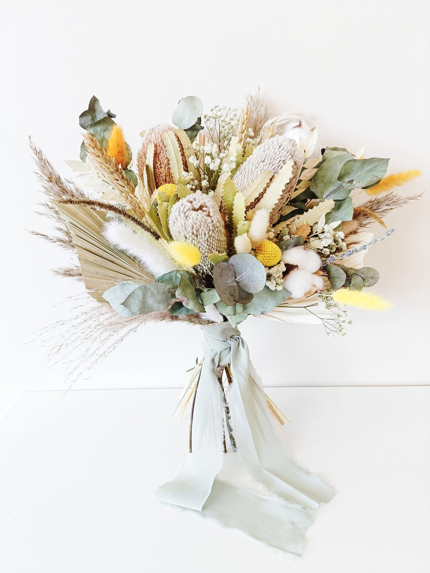 Australian native dried flower bridal bouquet with preserved banksia, eucalyptus, craspedia, and cotton – perfect for rustic or boho weddings.