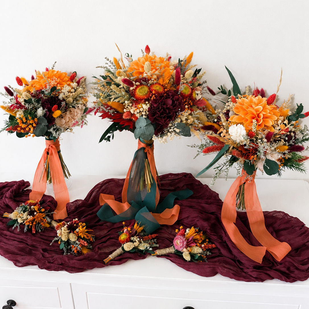 Complete autumn wedding flower set including bridal bouquet, bridesmaid bouquets and coordinating dried flower boutonnières in burnt orange and burgundy.