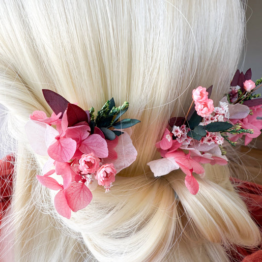 Elegant side profile of a wedding hairstyle with blush-toned flower clips and preserved greenery