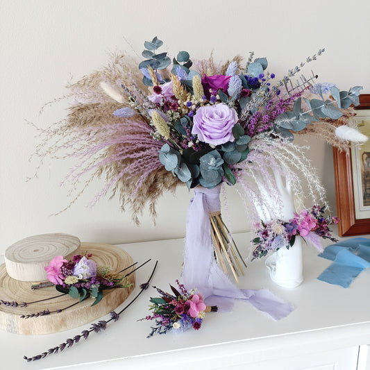 Dried flower bridal bouquet in lilac and purple tones with sola wood roses, preserved eucalyptus, lavender, and pampas grass – perfect for boho or rustic weddings. Hand-tied and wrapped with a soft ribbon.