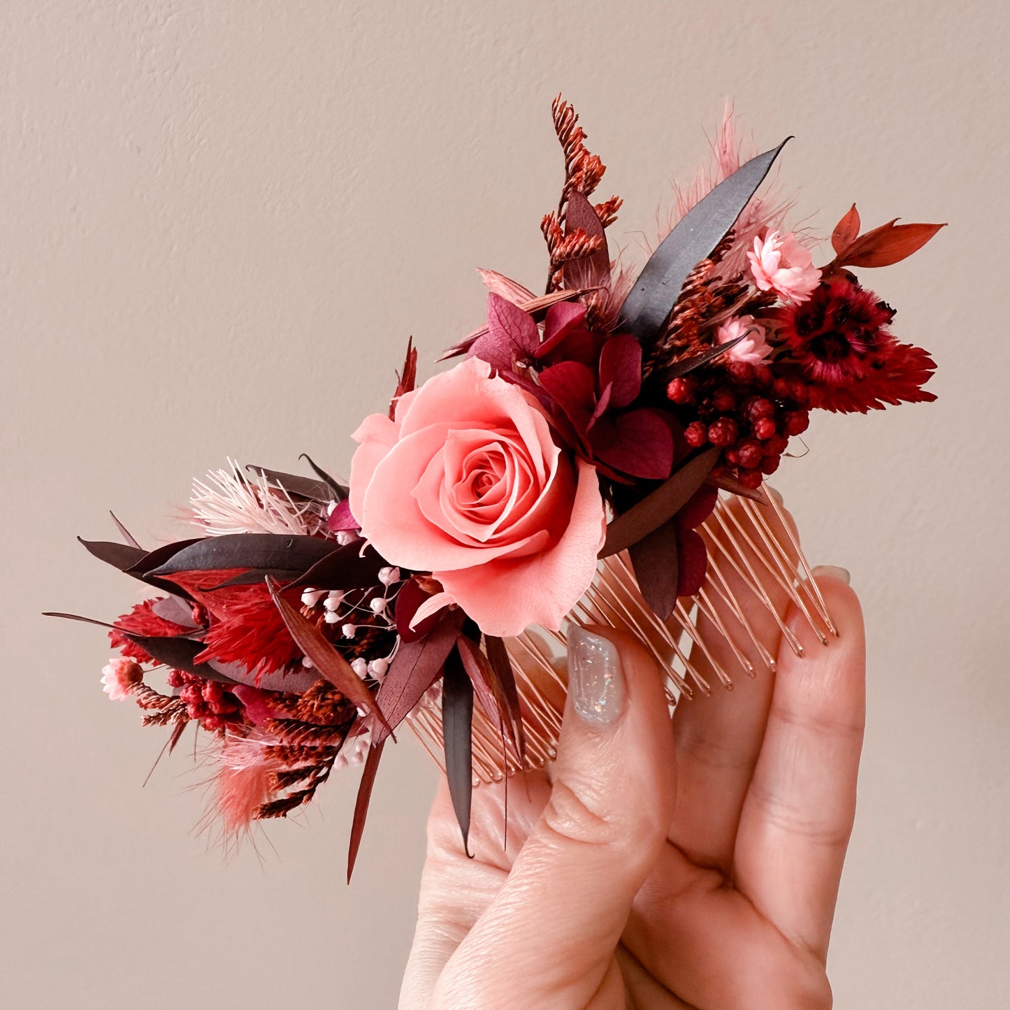 Boho wedding hair accessory with coral pink rose, dried burgundy flowers, and foliage on metal comb – handmade in Australia.