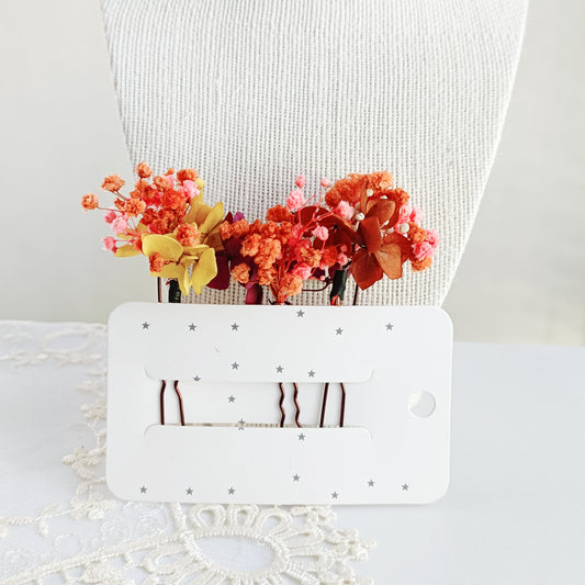 set of two handcrafted hair clips made from preserved autumn flowers. The clips are detailed with delicate pearl clusters and accented with natural textures for a bohemian feel.
