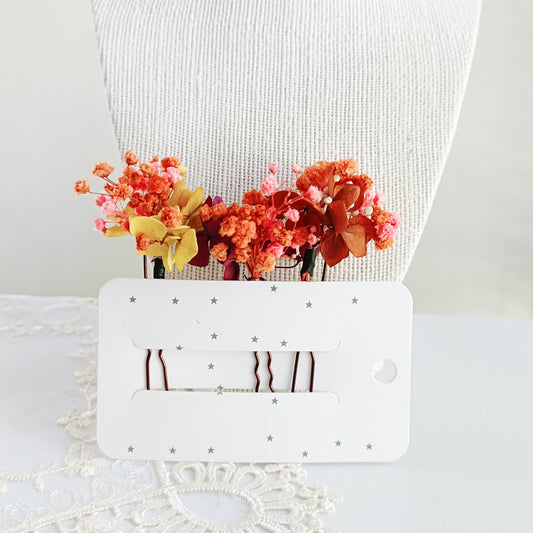 set of two handcrafted hair clips made from preserved autumn flowers. The clips are detailed with delicate pearl clusters and accented with natural textures for a bohemian feel.