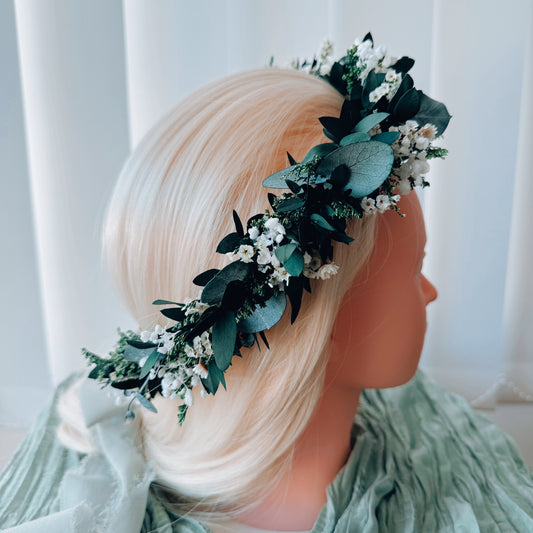 Front view of handmade dried flower crown with green and white preserved flowers.