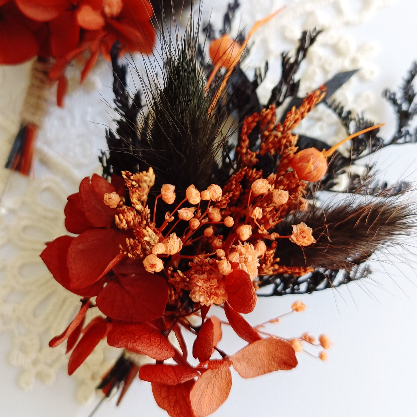 Groom’s boho boutonniere in terracotta and deep blue tones with dried grasses and twine wrap