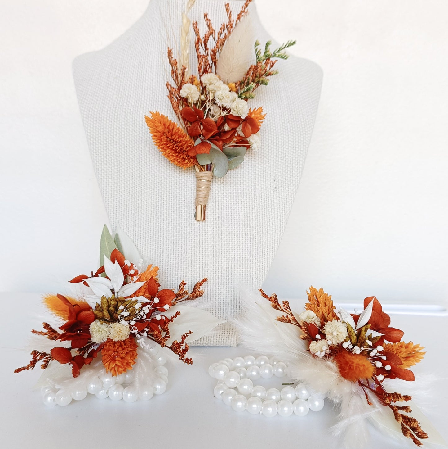 Handmade bridesmaid corsage with natural dried flowers in earthy tones and soft feather accents