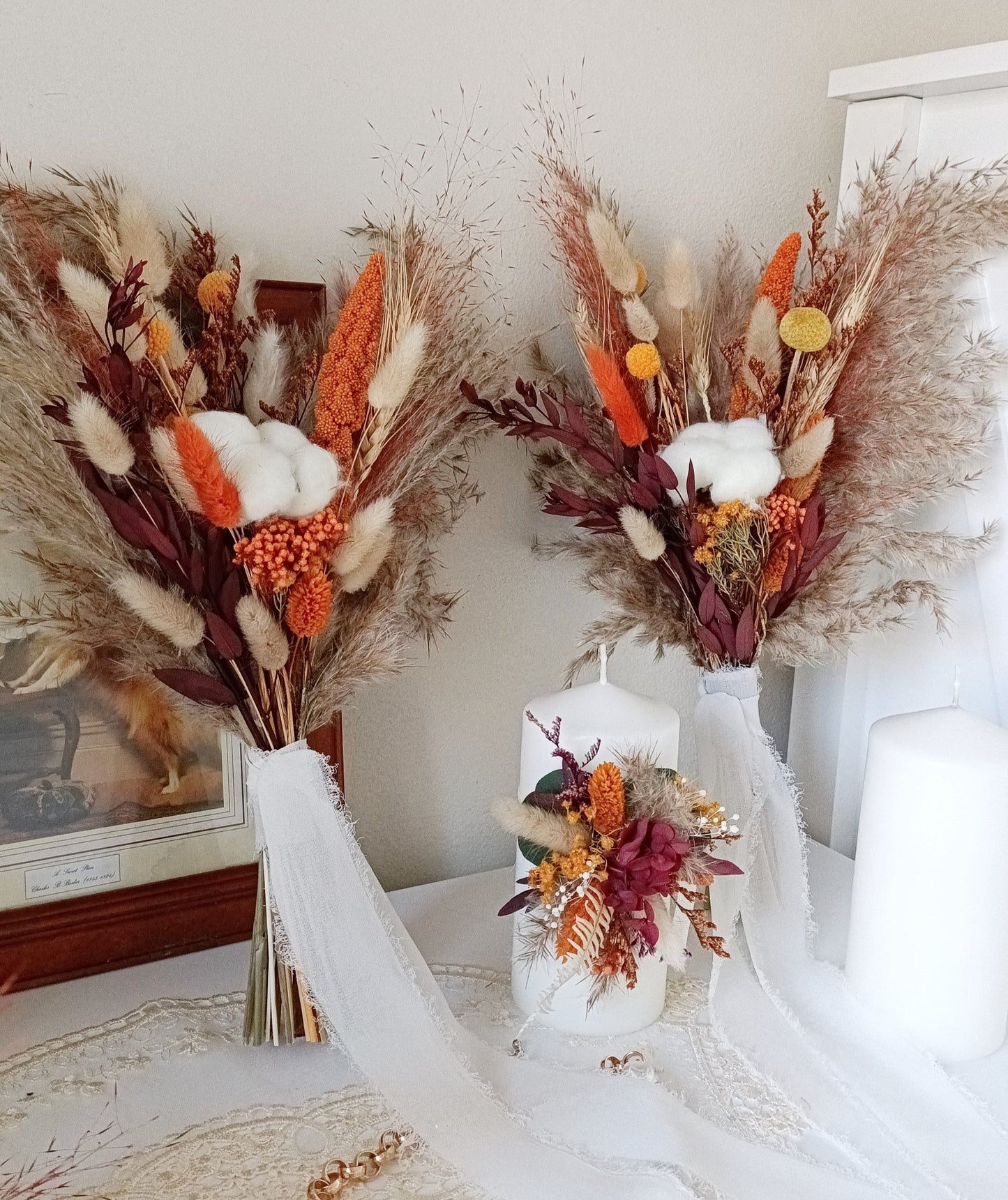 This stunning autumn-inspired wedding bouquet showcases a rich palette of dried flowers, featuring vibrant orange and earthy tones. The arrangement includes pampas grass, preserved foliage, and fluffy bunny tails, delivering a perfect blend of rustic charm and seasonal elegance. Ideal for a fall-themed wedding, this long-lasting bouquet offers a warm and inviting touch to your special day. Discover more seasonal bridal bouquets and wedding decor ideas in our collection