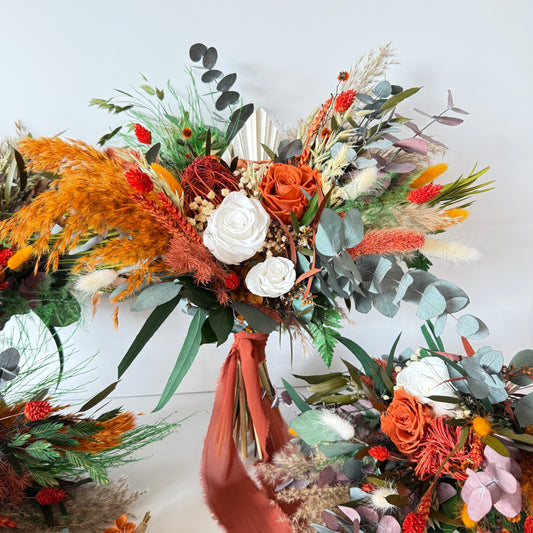 Dried bridesmaid bouquets in warm burnt orange tones with preserved roses, eucalyptus, pampas and natural textures for rustic weddings