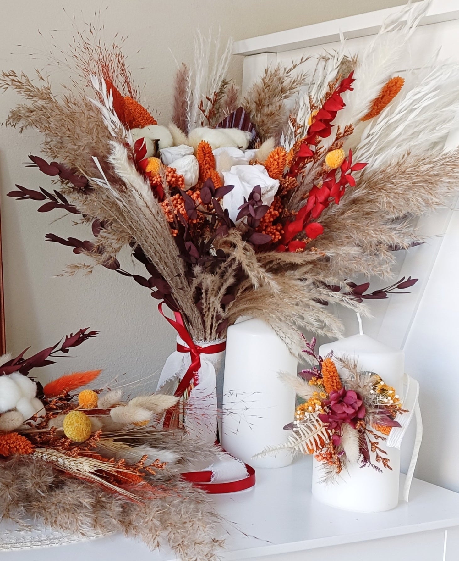 This eye-catching wedding bouquet features a bold combination of red, orange, and natural hues, crafted from a selection of dried flowers. The arrangement includes pampas grass, preserved foliage, and textured accents, offering a rustic yet vibrant look perfect for autumn weddings. Long-lasting and full of character, this bouquet adds a fiery touch to any bridal ensemble. Explore our collection for more unique and seasonal wedding bouquets.