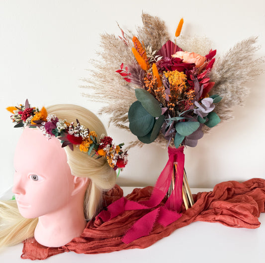 Boho flower crown made of dried flowers in orange, yellow, burgundy, and purple tones, styled on a mannequin head — perfect bridal hair accessory for rustic or autumn weddings.