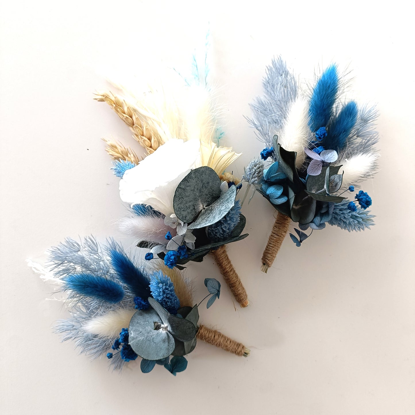 Dusty blue and ivory dried wedding boutonniere set featuring hydrangea, wheat, and twine wrap