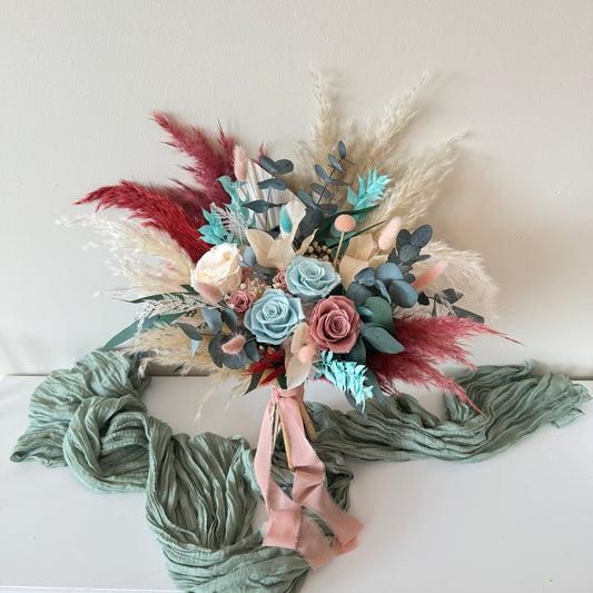 Boho rustic bridal bouquet featuring fluffygrass, preserved eucalyptus, dusty blue and blush roses with silk ribbon wrap