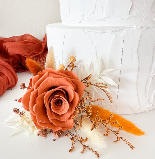 Rustic dried flower cake topper featuring orange, ivory and mustard tones for boho weddings