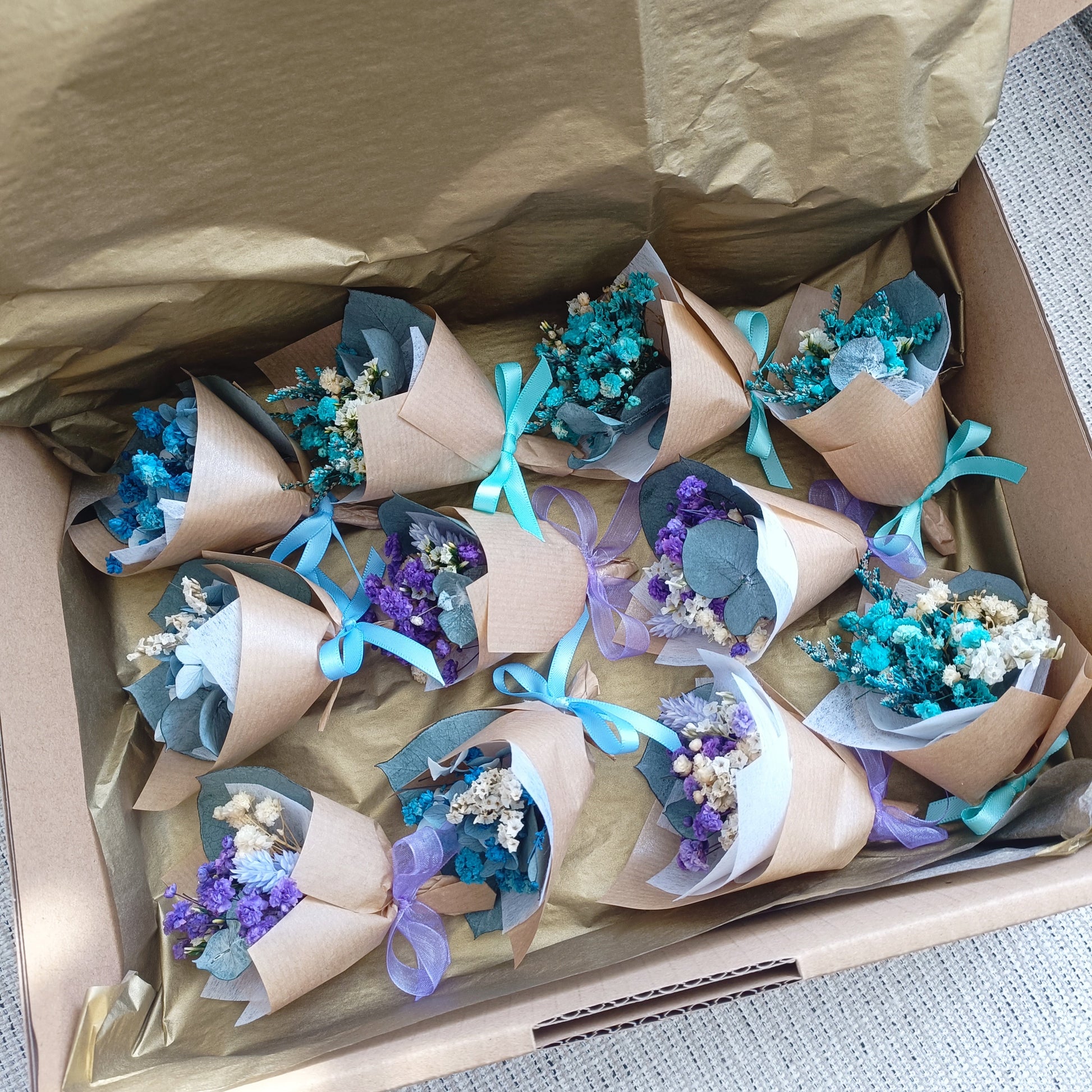 Collection of mini teal bouquets ready for packaging, ideal as sustainable wedding favours.