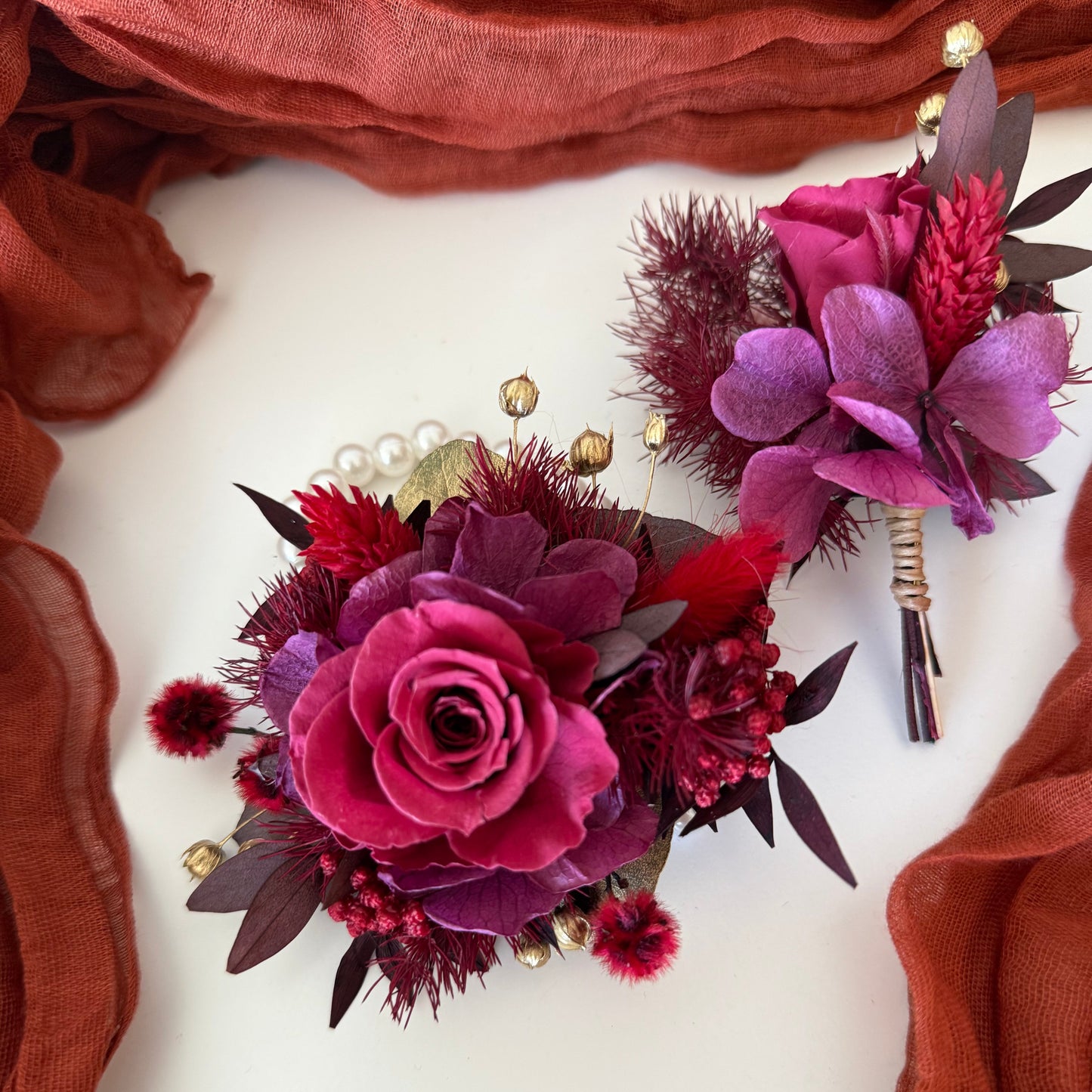 Elegant burgundy wrist corsage on pearl bracelet with matching boutonniere for prom or wedding
