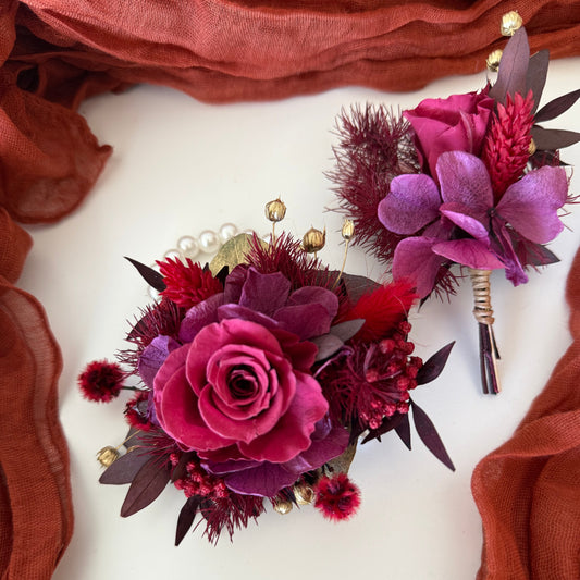 Elegant burgundy wrist corsage on pearl bracelet with matching boutonniere for prom or wedding