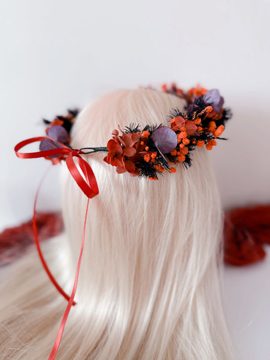 Side view of burnt orange and plum flower crown with preserved blooms and eucalyptus leaves.