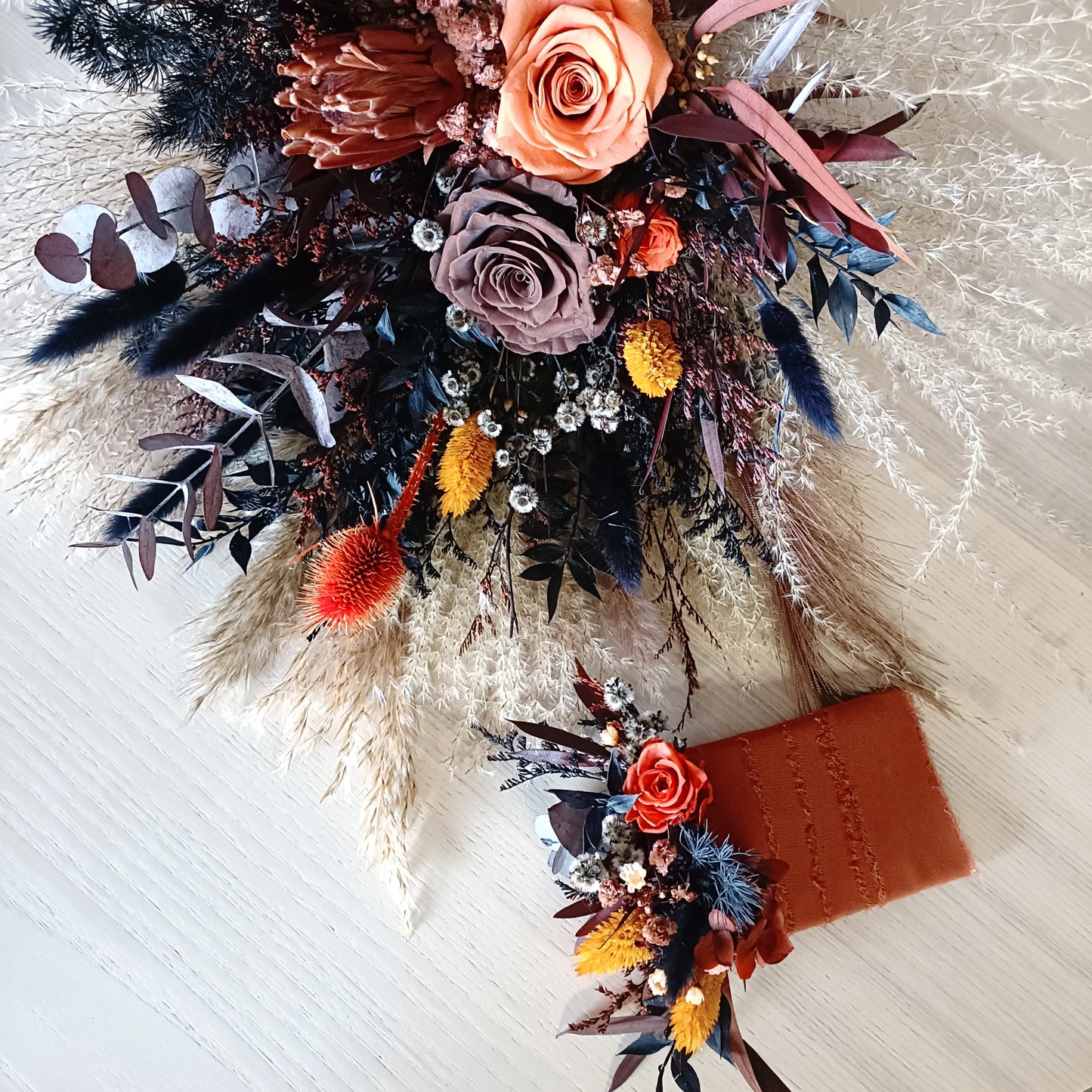 Burnt orange and navy dried flower boutonniere with preserved hydrangea and natural textures