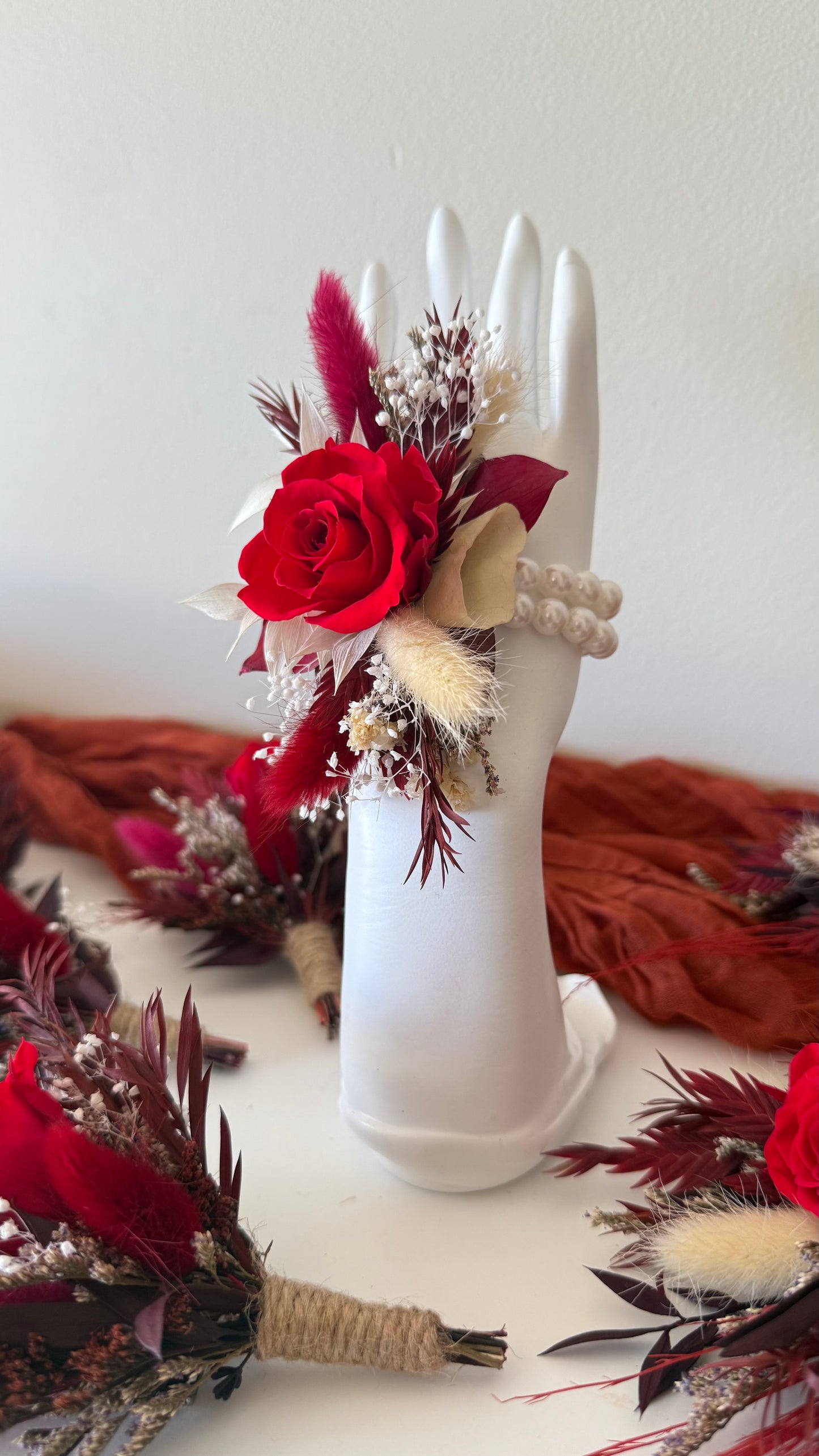 Burgundy rose wrist corsage with dried and preserved flowers, elegant boho wedding accessory.