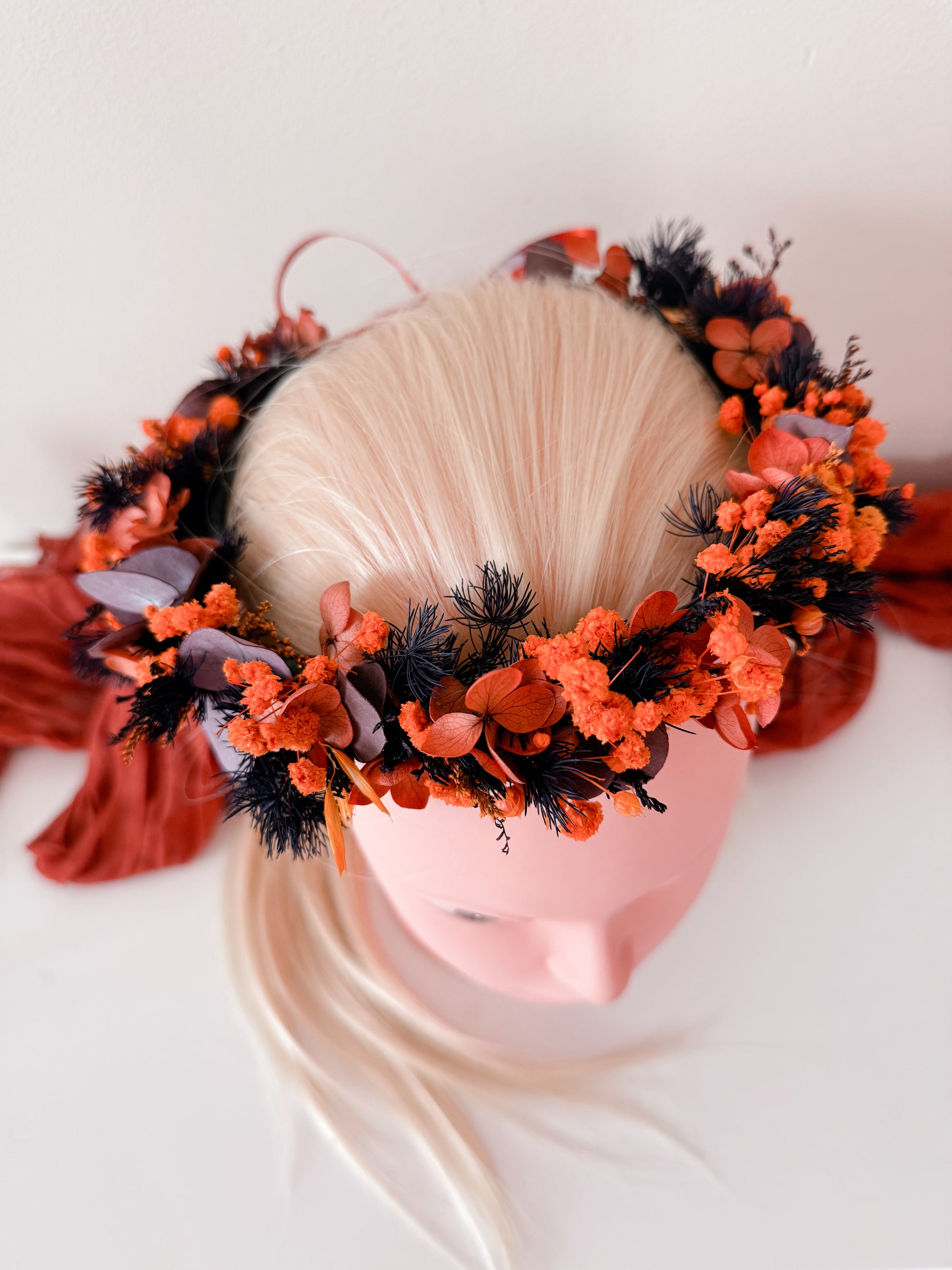 Dried floral headpiece on white mannequin with burnt orange and purple flowers – Australian wedding hair crown