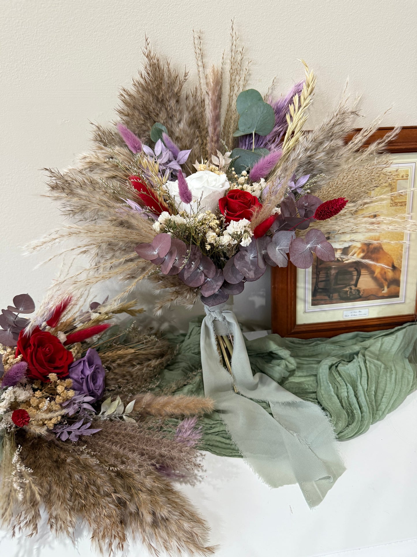 dried floral arrangement with dried elements and ribbons on a light background