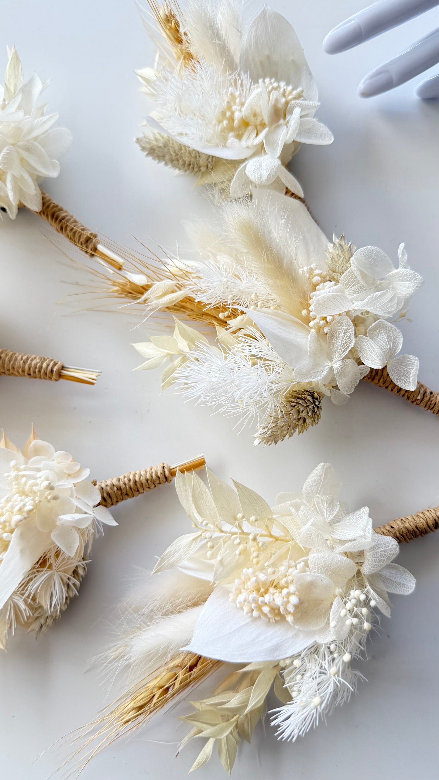 Decorative floral hair accessories with dried flowers and gold accents on a light background