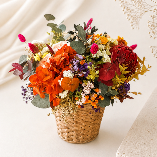 Bouquet of colorful flowers in a woven basket on a light background