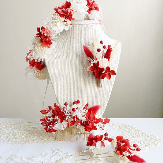 A delicate dried flower crown featuring a bold mix of red and white petals, adorned with tiny pearl accents. The wreath is tied with sheer ribbon, creating an elegant, romantic look for a wedding or special occasion.