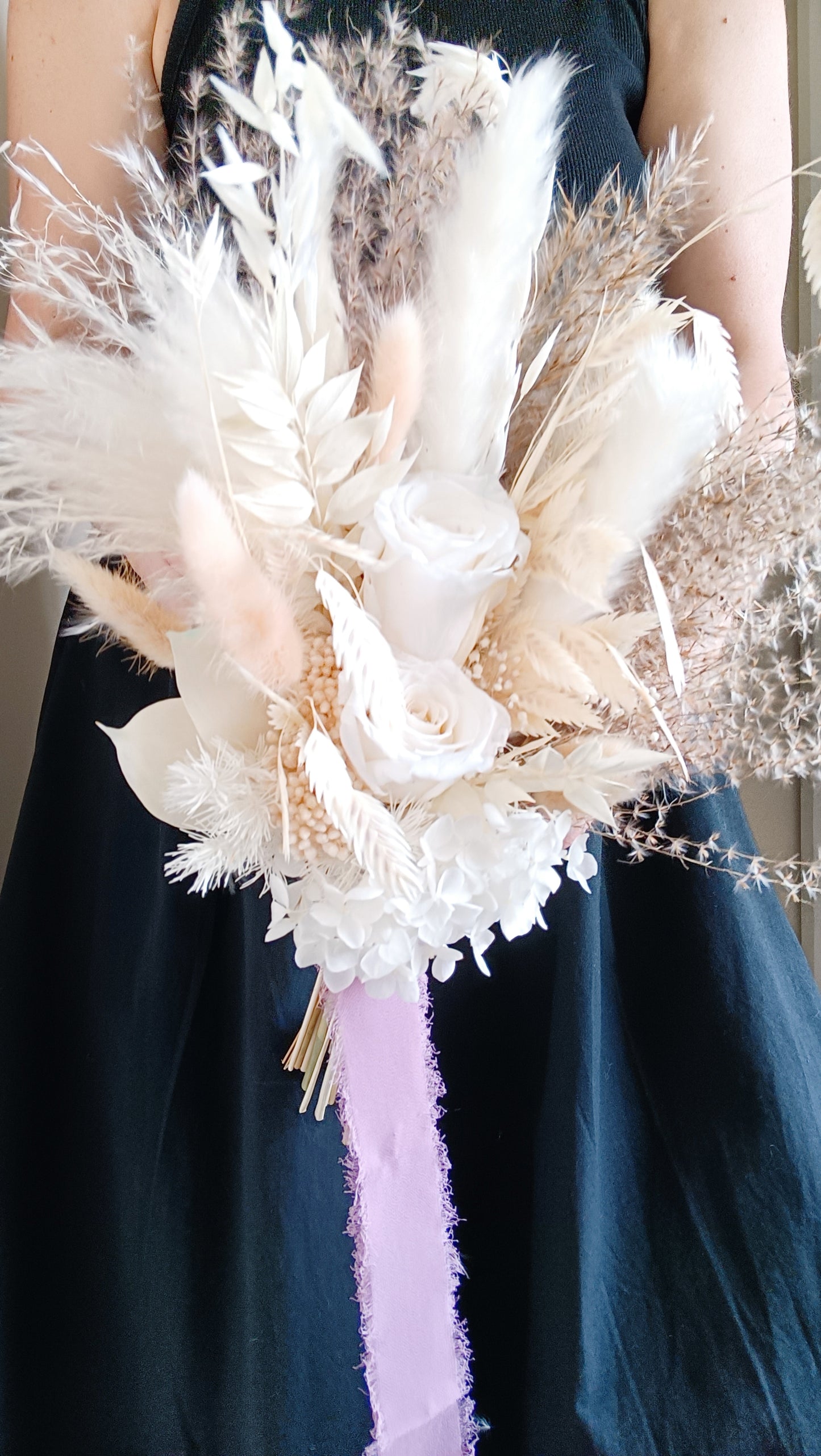 Free-form dried flower bridal bouquet in ivory tones featuring pampas, bunny tails, and preserved florals. Ideal for boho, rustic, or modern weddings.