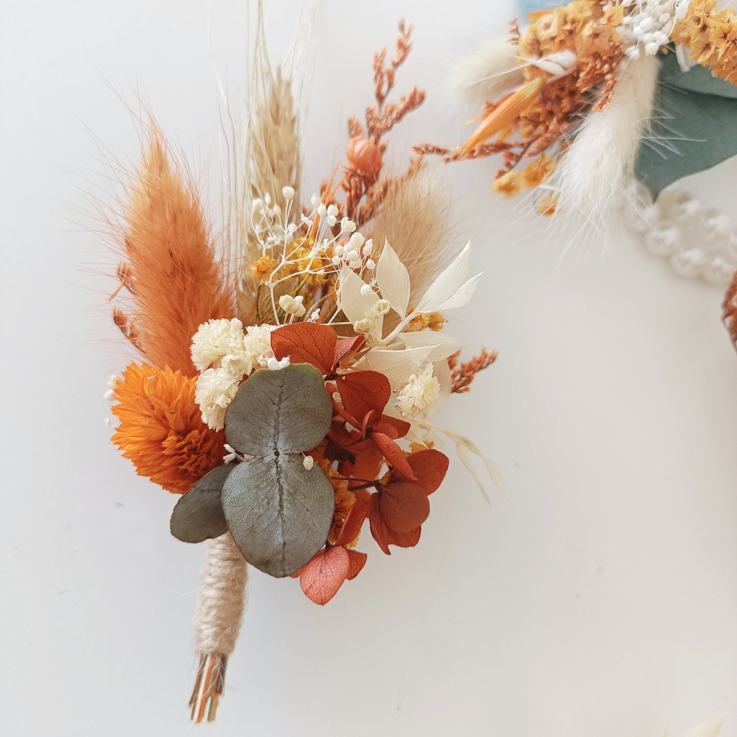 Rustic dried flower boutonniere in terracotta, ivory and sage tones with preserved eucalyptus and bunny tails