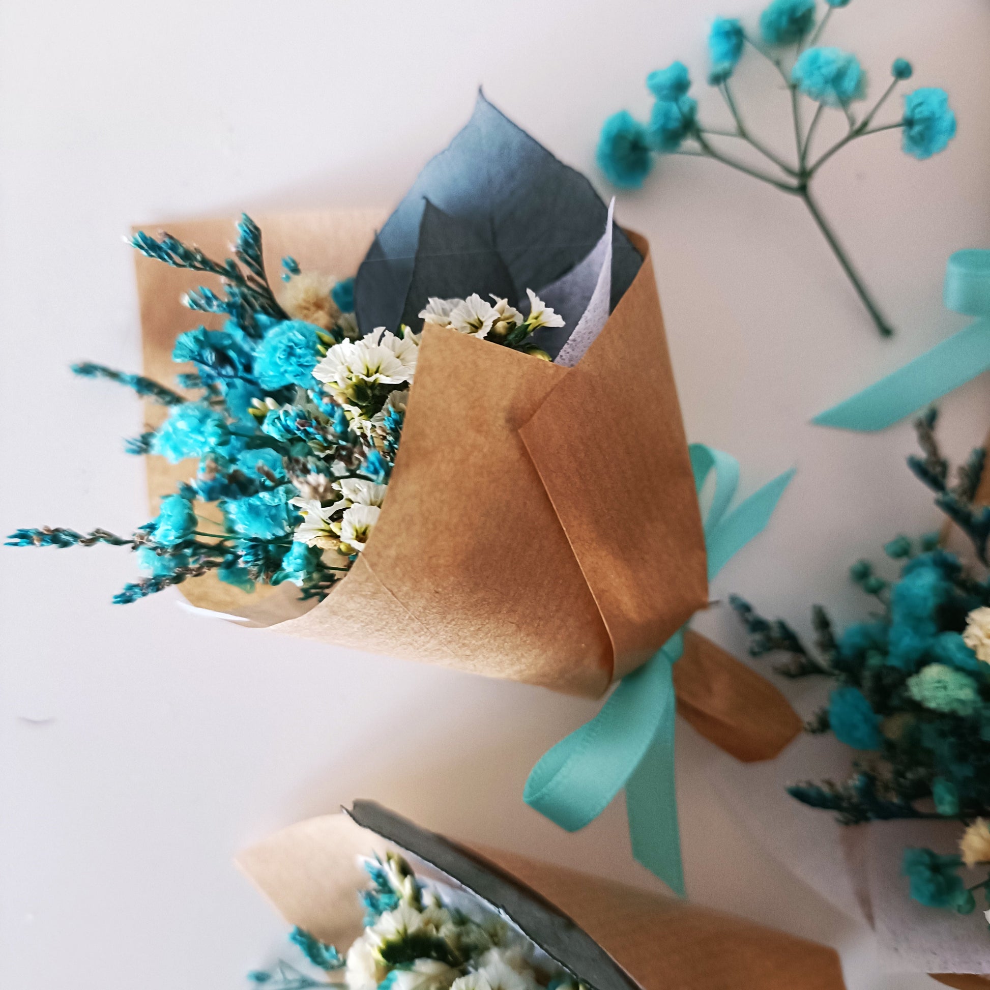 Set of mini teal dried flower favours with eucalyptus and preserved blooms, ideal for events and thank-you gifting.