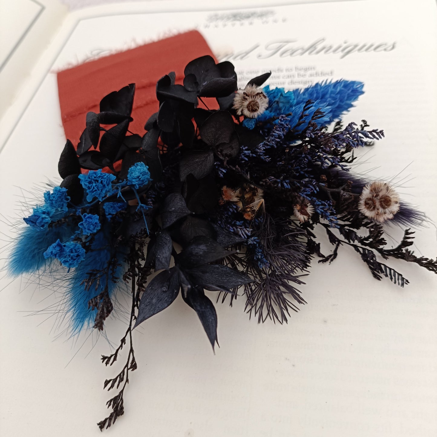 Handcrafted dried flower buttonhole with black eucalyptus, blue bunny tails and textured wrap