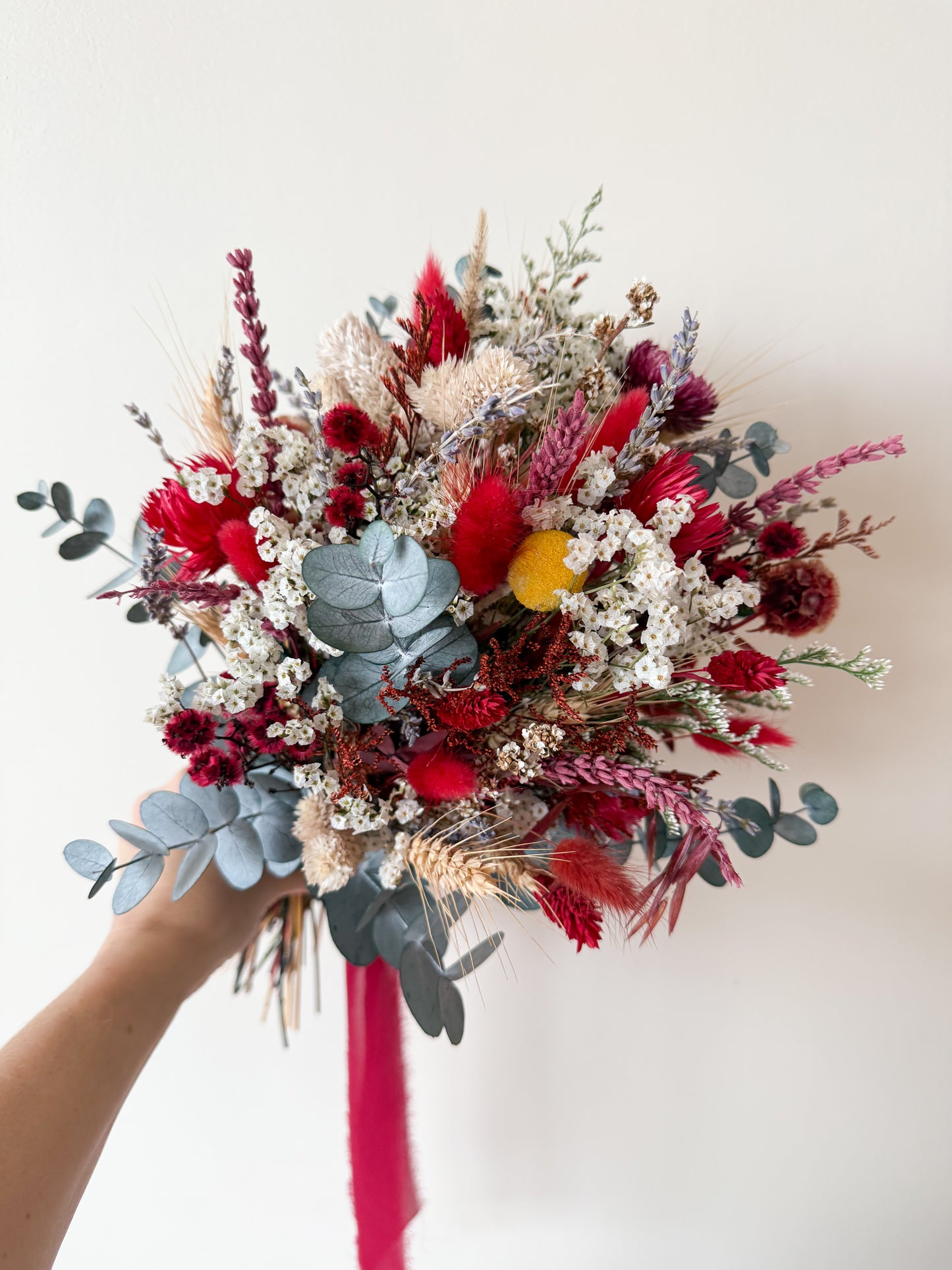 Preserved wildflower bridal bouquet featuring red billy balls, white statice and eucalyptus sprigs