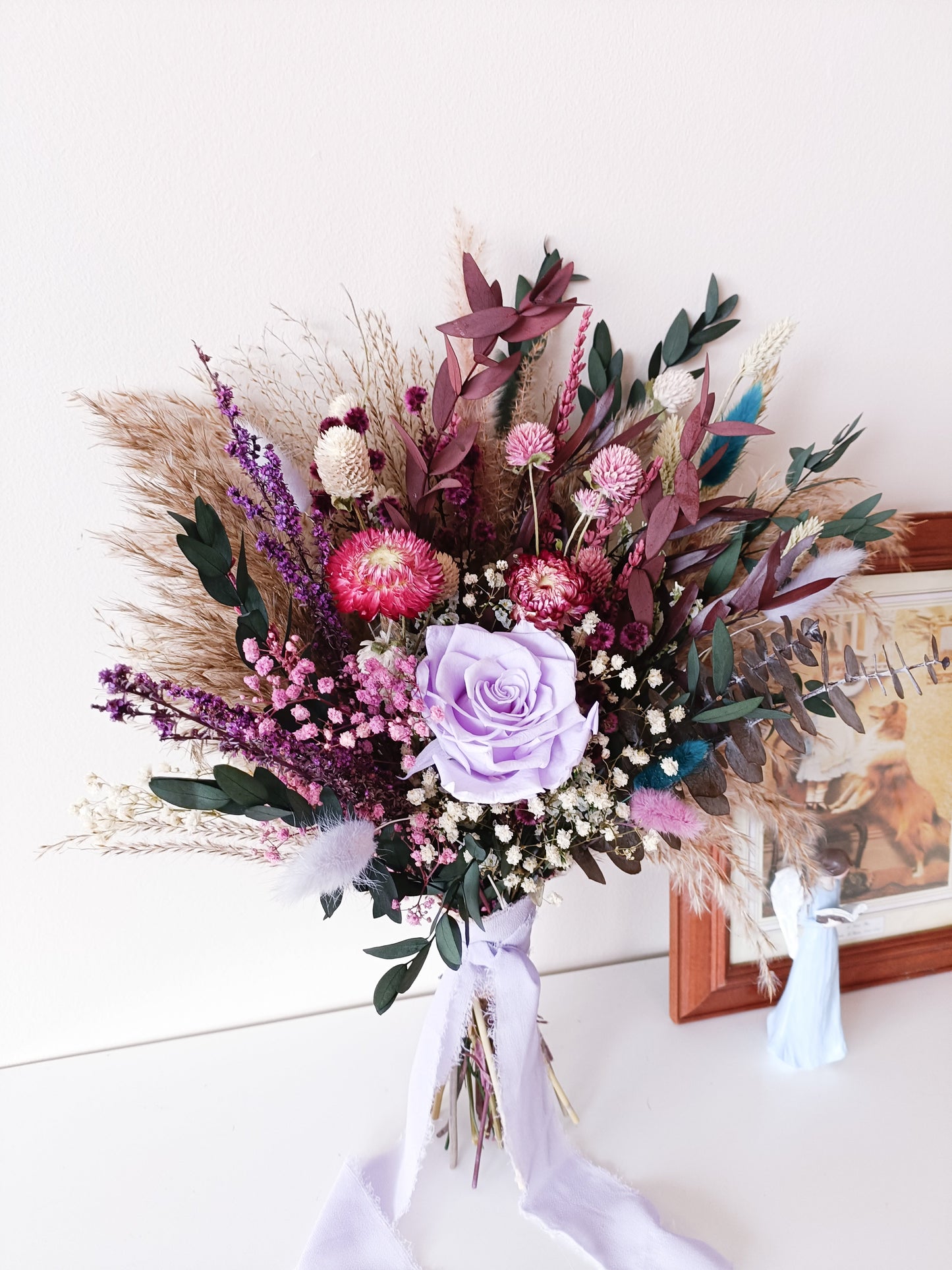 Dried flower bridal bouquet with lilac sola rose, strawflower, pampas grass, and preserved greenery – perfect for rustic or boho weddings