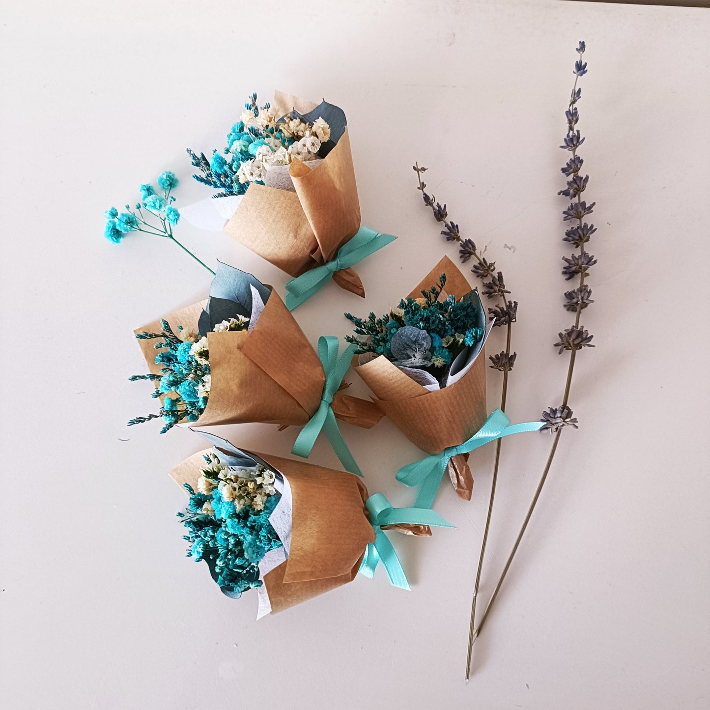 Elegant rustic dried flower mini bouquet with blue and cream flowers, tied with satin ribbon.
