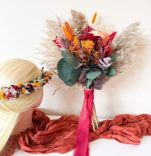 Rustic wedding bouquet featuring dried roses, pampas grass, orange, red, and yellow florals tied with a silk ribbon — handmade boho bouquet for brides