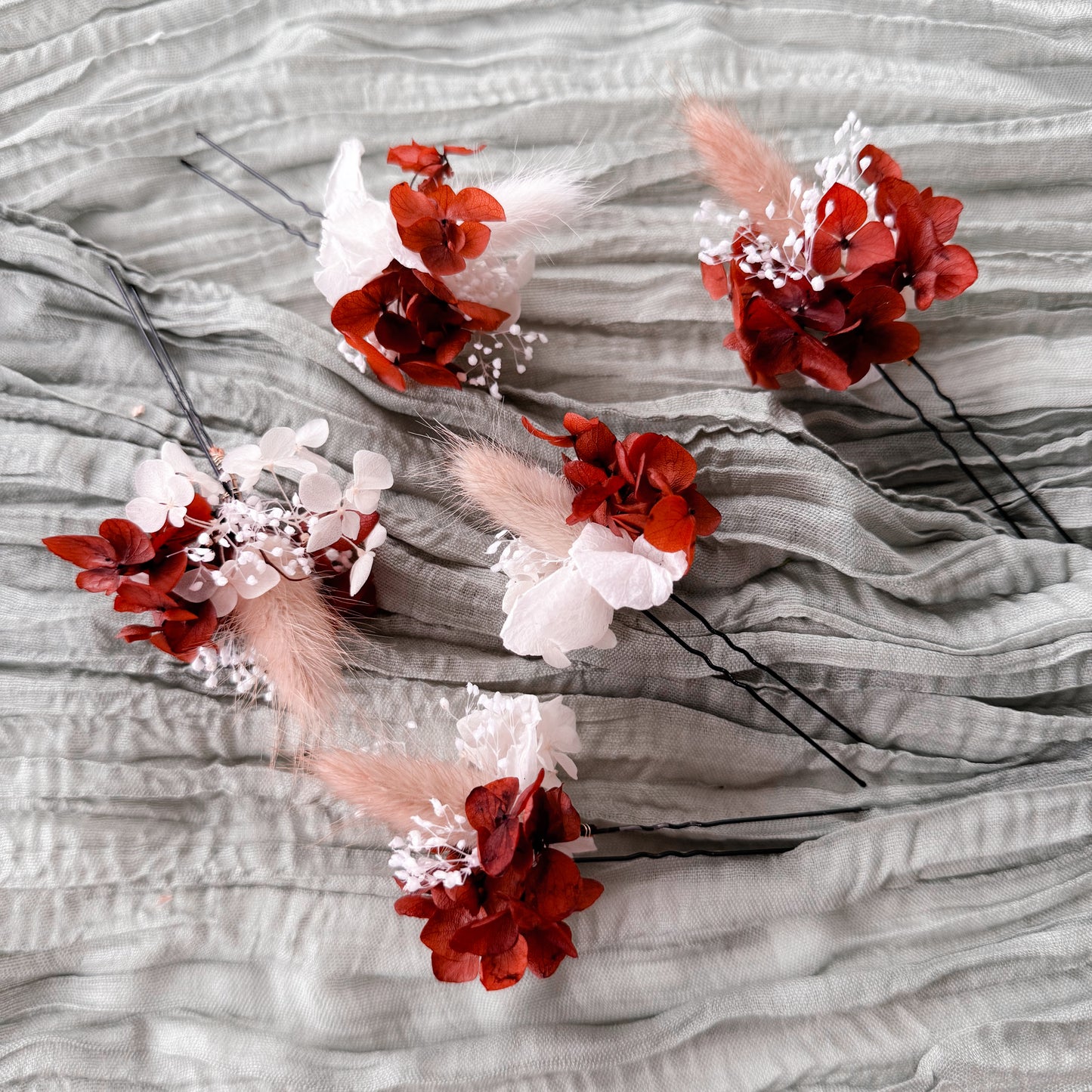 terracotta and white floral hair pins on a textured gray surface