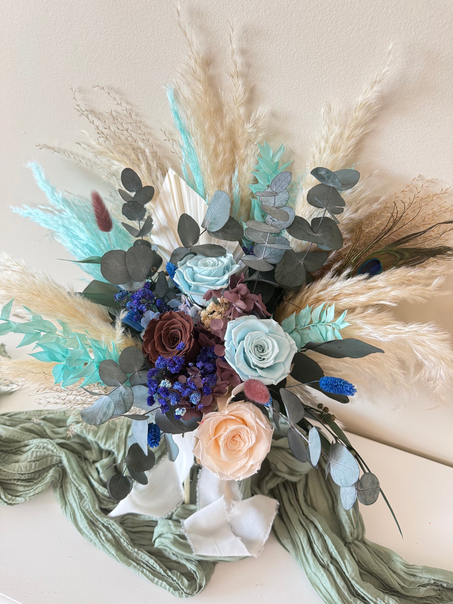 Handcrafted teal blue dried flower arrangement with beige sola roses and preserved eucalyptus.