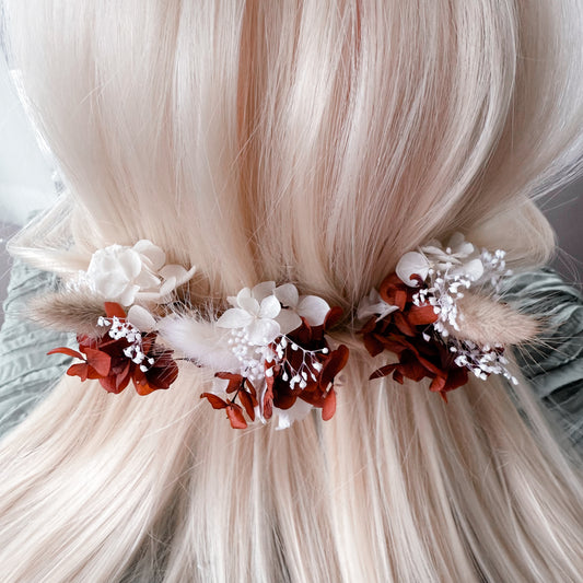 Blonde hair with floral hair accessories on a neutral background