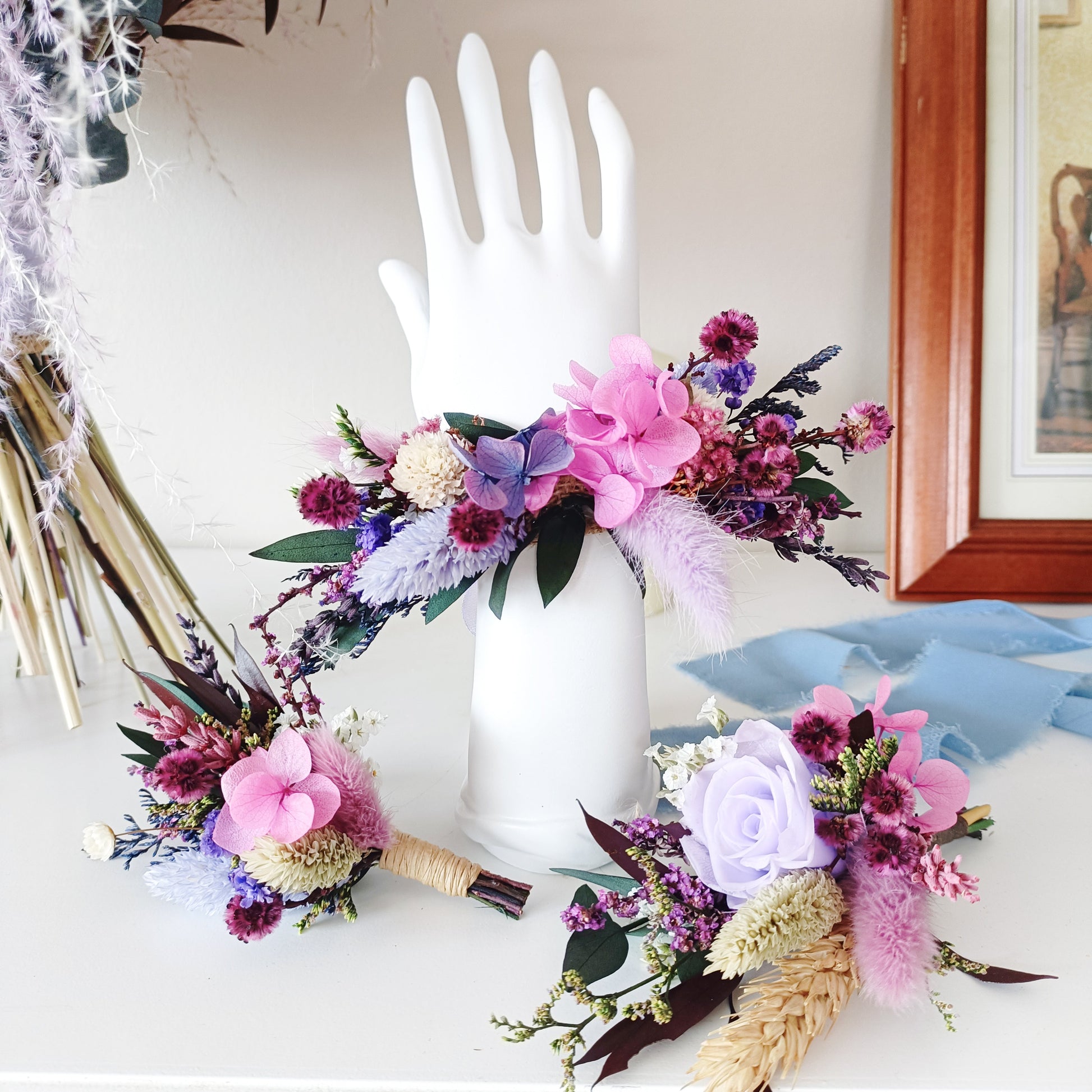 Romantic dried flower set featuring a floral bracelet and boutonnieres in soft pink, violet, and cream shades – perfect for bridesmaids, formal events, or gift sets. Includes preserved blooms and rustic textures.