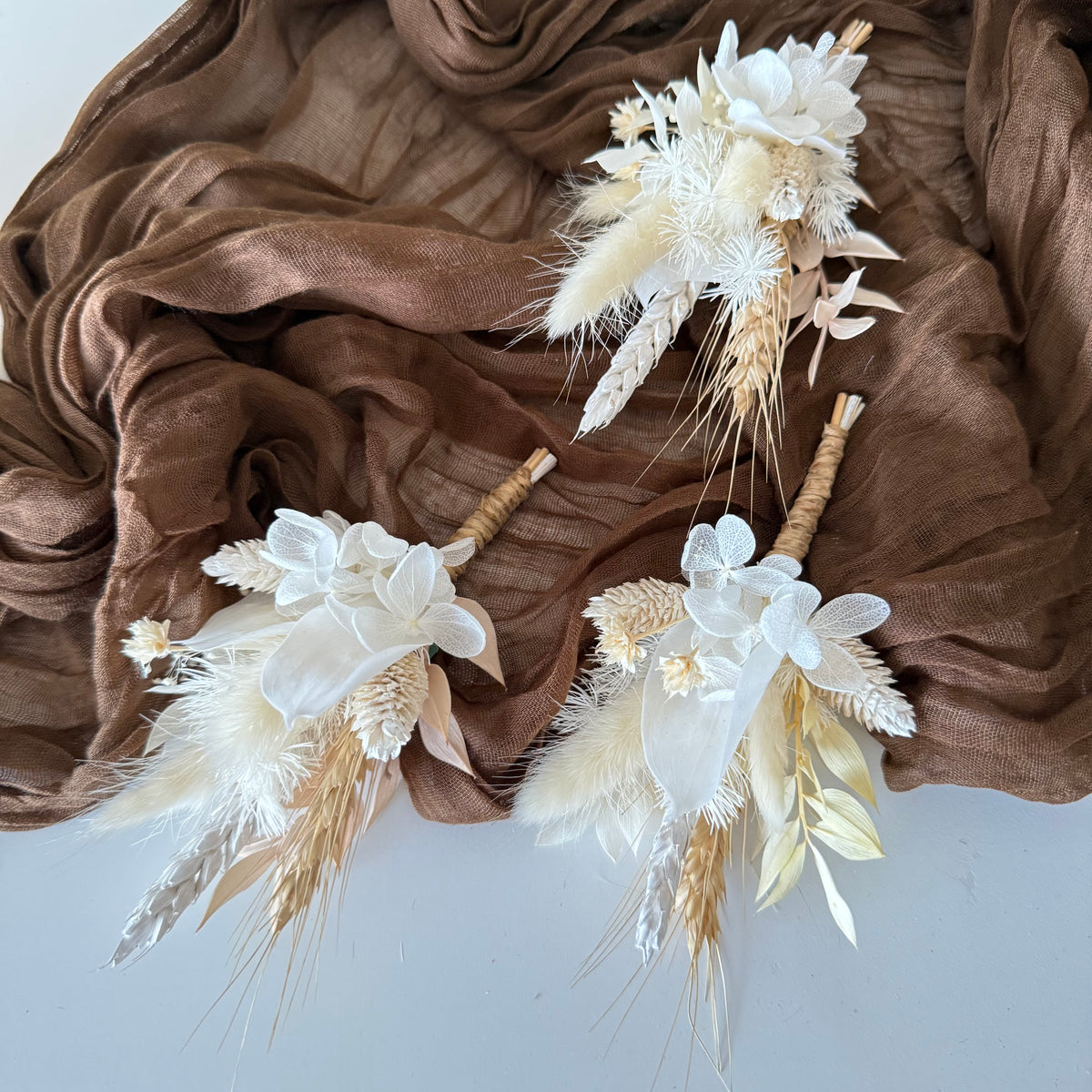 White and ivory dried flower wedding boutonnieres with preserved hydrangea, pampas grass and natural dried foliage