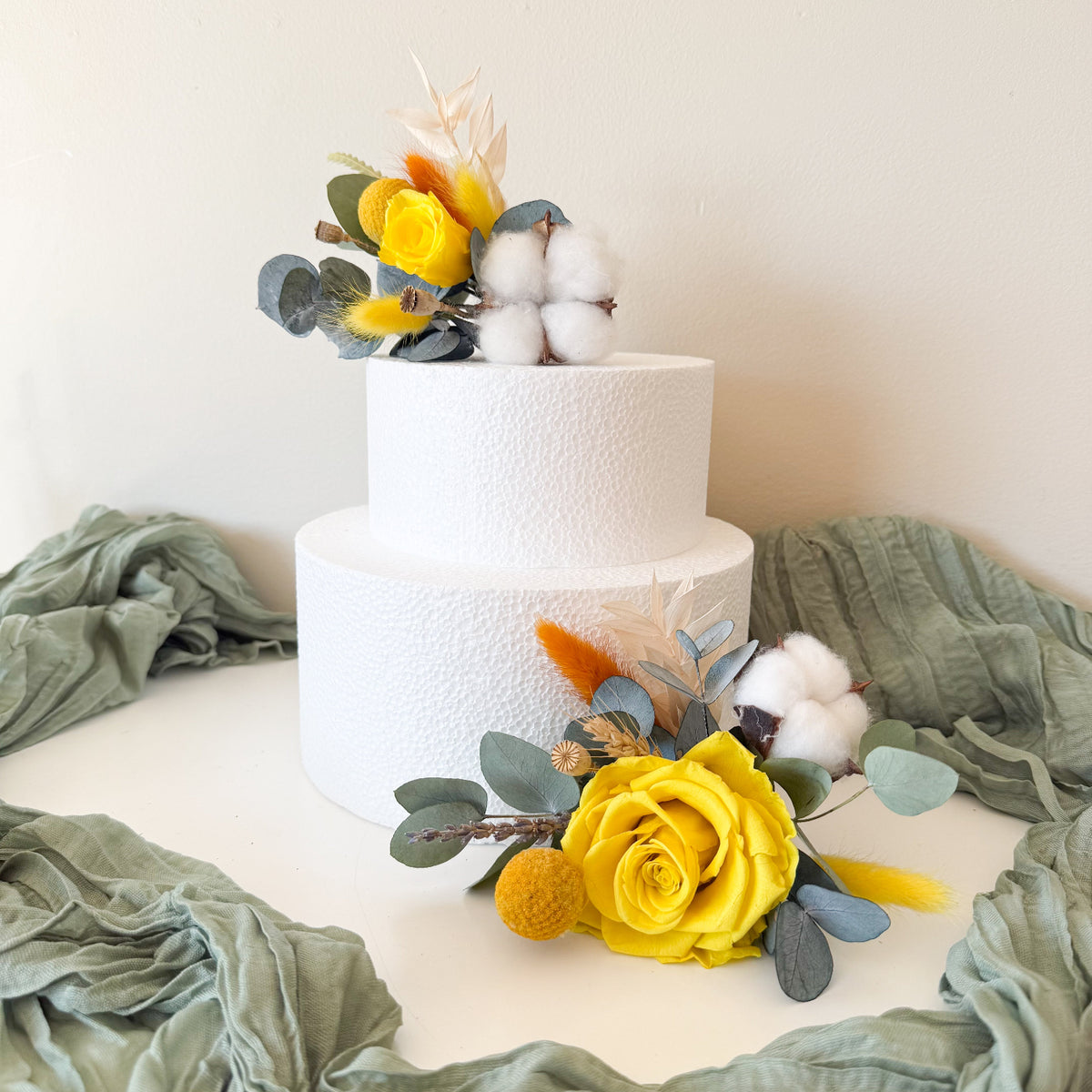 Rustic boho wedding cake decorated with yellow sola roses, billy buttons and eucalyptus, featuring handcrafted dried flower cake toppers.