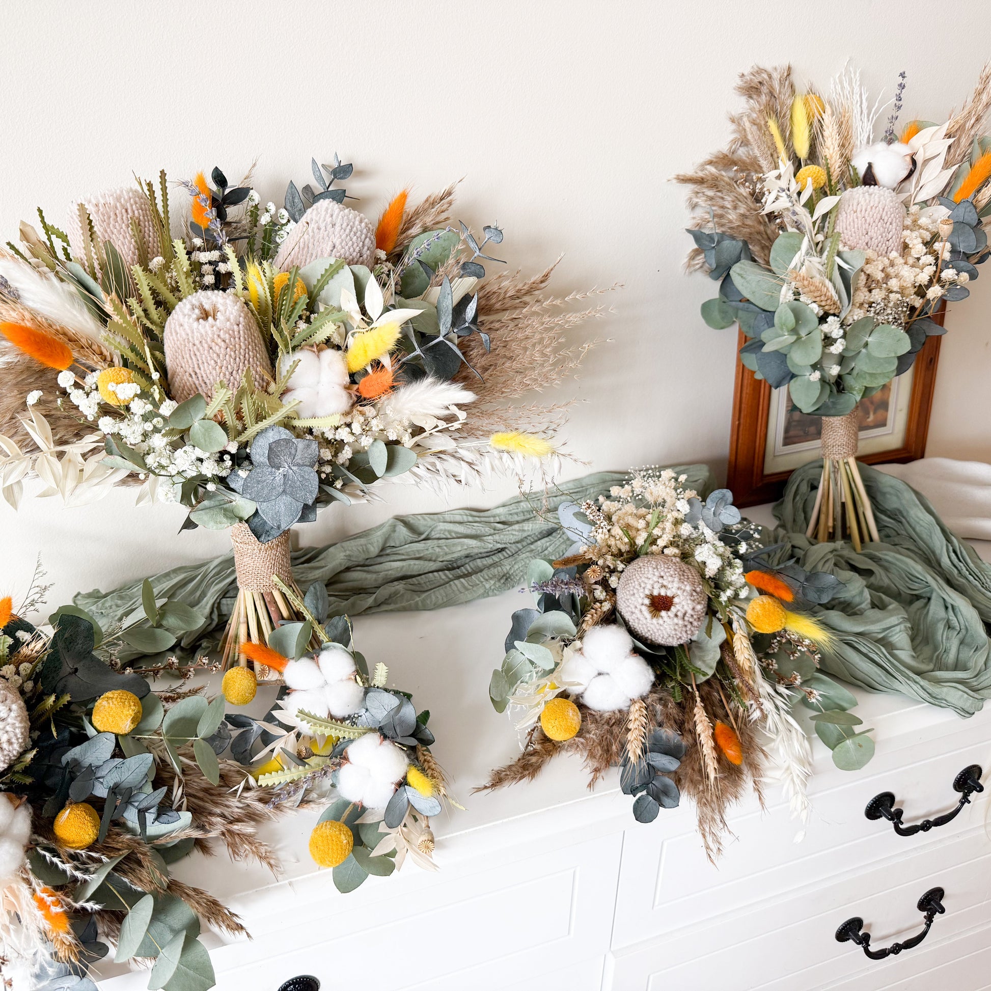 DRIED WEDDING flower arrangements on a white surface with a neutral background