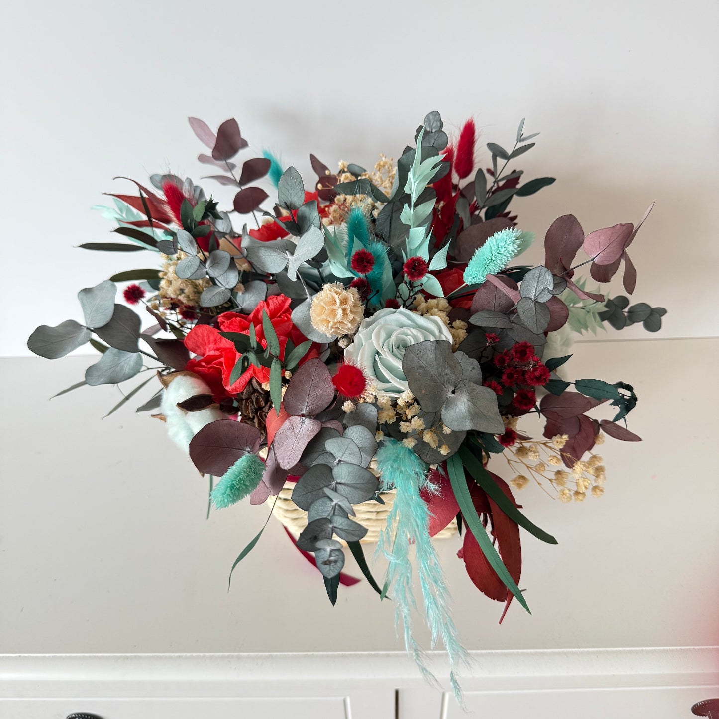 Affordable dried Christmas flower basket in bright red and mint tones, long-lasting festive floral arrangement.