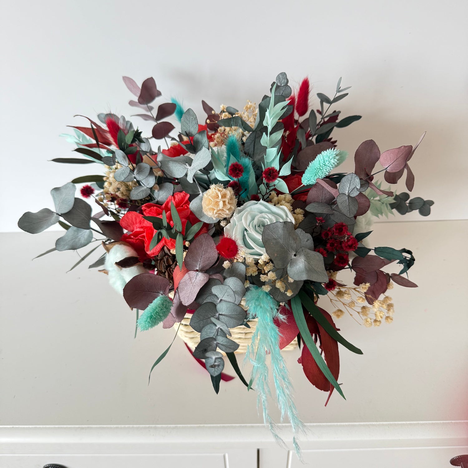 Affordable dried Christmas flower basket in bright red and mint tones, long-lasting festive floral arrangement.