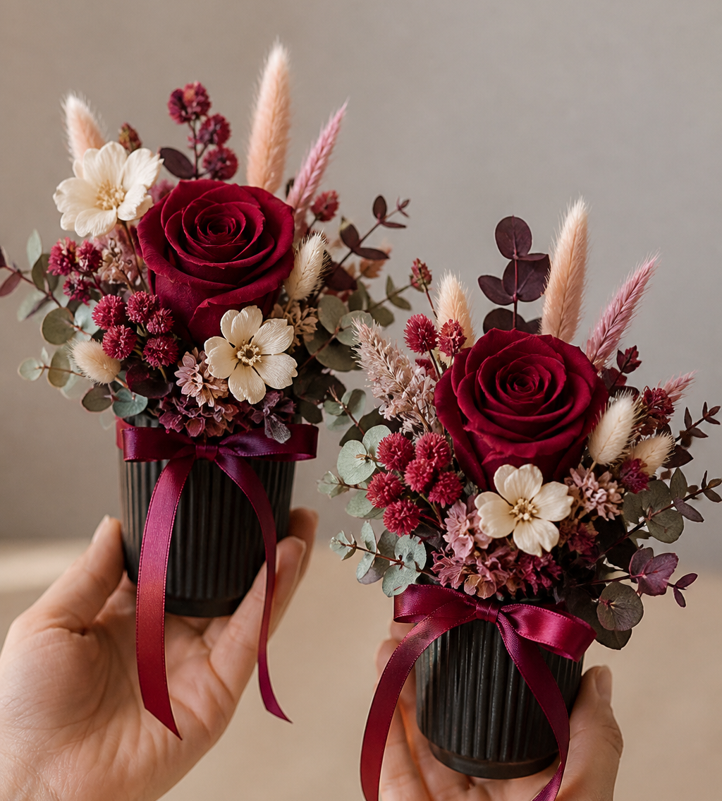  small floral arrangements with red and pink flowers held by hands against a neutral background