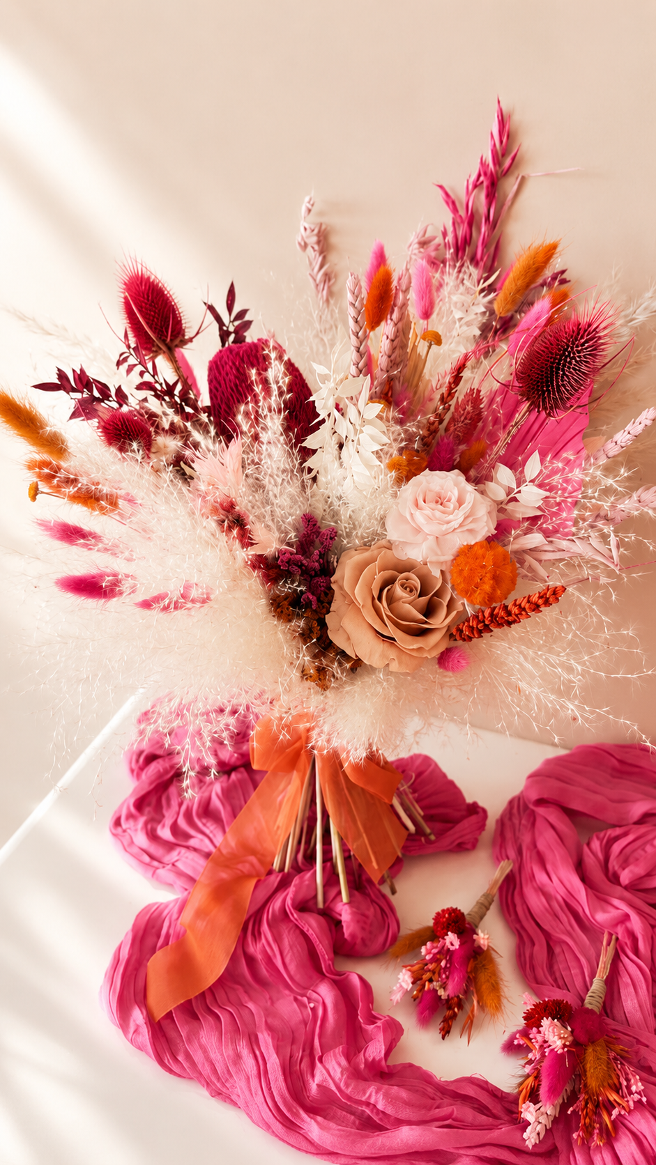 Bouquet of flowers with pink and orange accents on a white surface